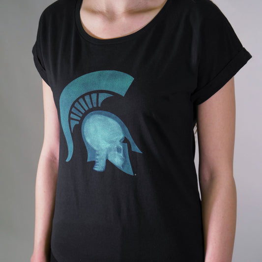 Woman wearing black short sleeve T-shirt with a scoop neck with a graphic of a head wearing a Spartan Helmet being x-rayed.