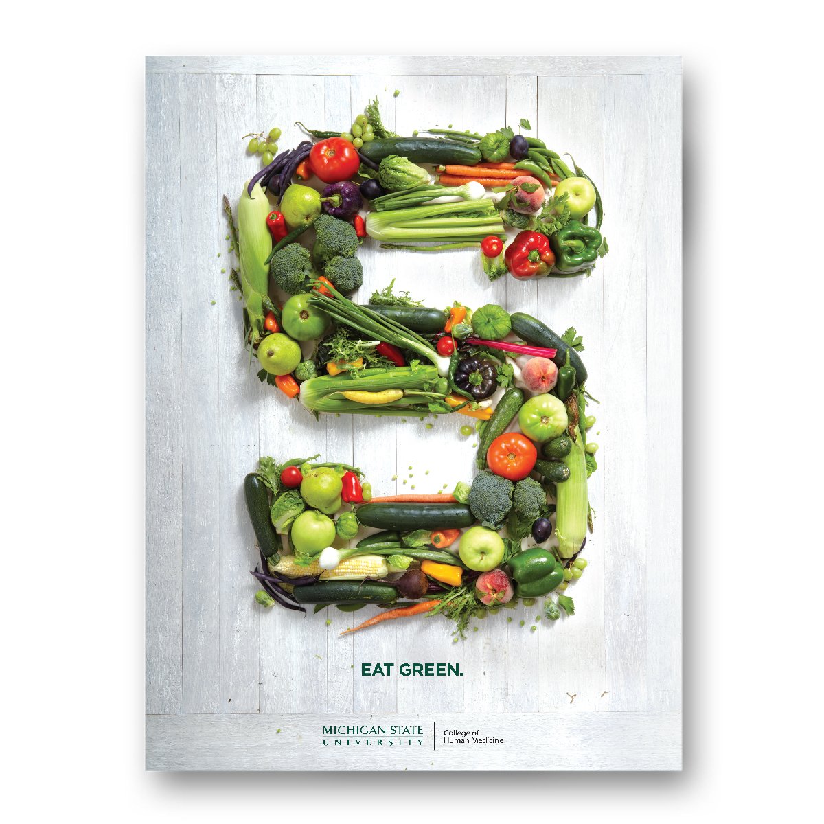 Vegetables stacked in the shape of a block s on a white wood surface. Text underneath reads "Eat Green" above the College of Human Medicine wordmark logo.