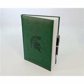 Kelly green leather-looking journal standing slightly open with lined pages and a black pen held on the outside. The cover is embossed with a Spartan Helmet logo and the "College of Human Medicine" wordmark.