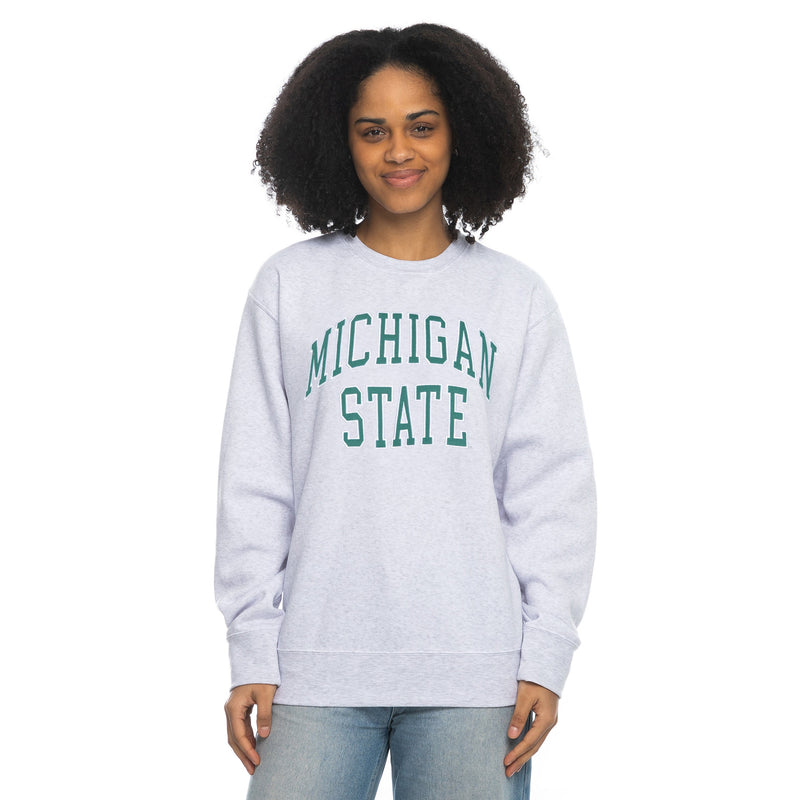 Person in light gray 'Michigan State' sweatshirt and light blue jeans.