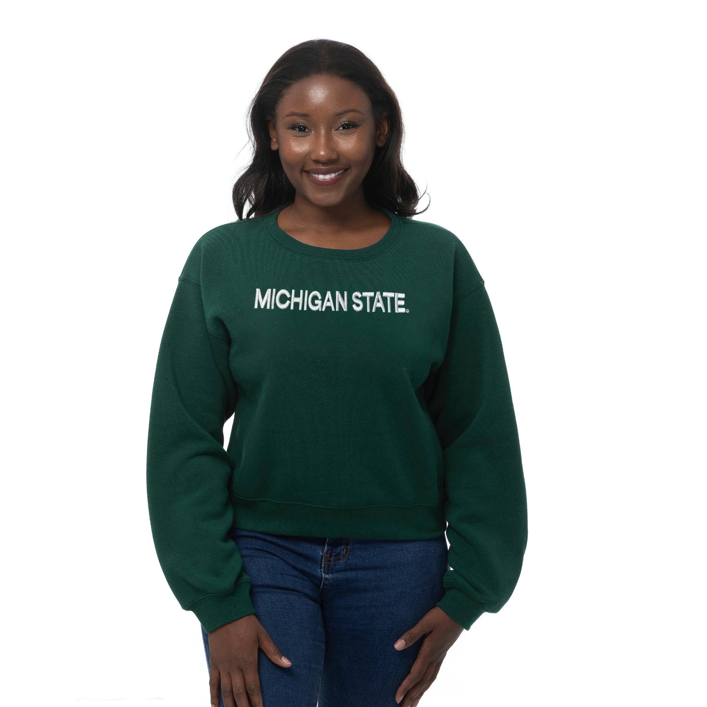 Person wearing a cropped green crewneck sweatshirt with a white "Michigan State" wordmark on the front. Shown on a white background.