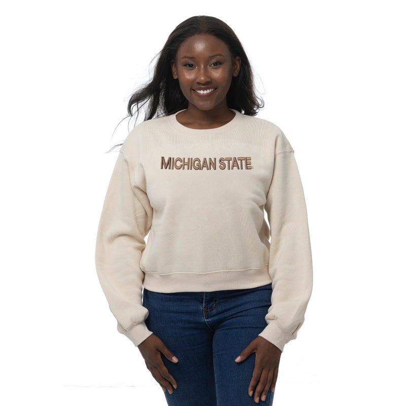 Woman wearing a beige 'Michigan State' sweatshirt on a white background