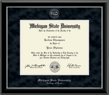 The diploma is enclosed in a dark wood frame with a black suede matte and silver trim, and includes signatures from university officials. Top of matting silver embossed Michigan State University seal. Bottom of frame in silver cursive letters is 'Michigan State University'. Below in silver and cursive letters is 'College of Law'. 