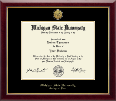 The diploma is displayed in a dark wood frame with a black matte and gold trim, and includes signatures from university officials. In gold and cursive writing is "Michigan State University." Below in gold cursive letters is "College of Law."