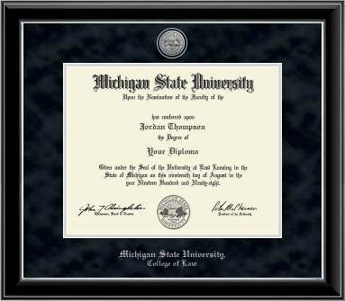 The diploma is enclosed in a black frame with silver accents and set against a black suede matte with silver outline around opening for diploma. Top of matting is silver engraved Michigan State University seal. Silver cursive letters is 'Michigan State University' at bottom. Below in silver cursive letters 'College of Law'.