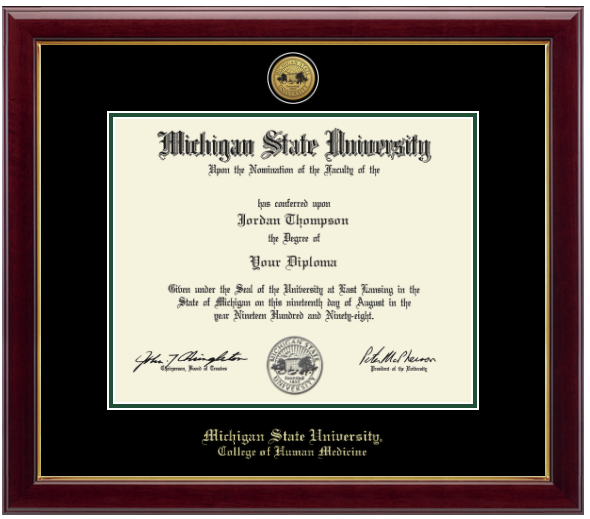 Framed Michigan State University diploma in a dark wood frame with a green inner edge. The matte is black with a gold inner border surrounding the diploma. Michigan State Seal is at the top of matte and is gold engraved. 'Michigan State University' is inscribed in gold at the bottom of the frame. Below Michigan State University is 'College of Human Medicine'.