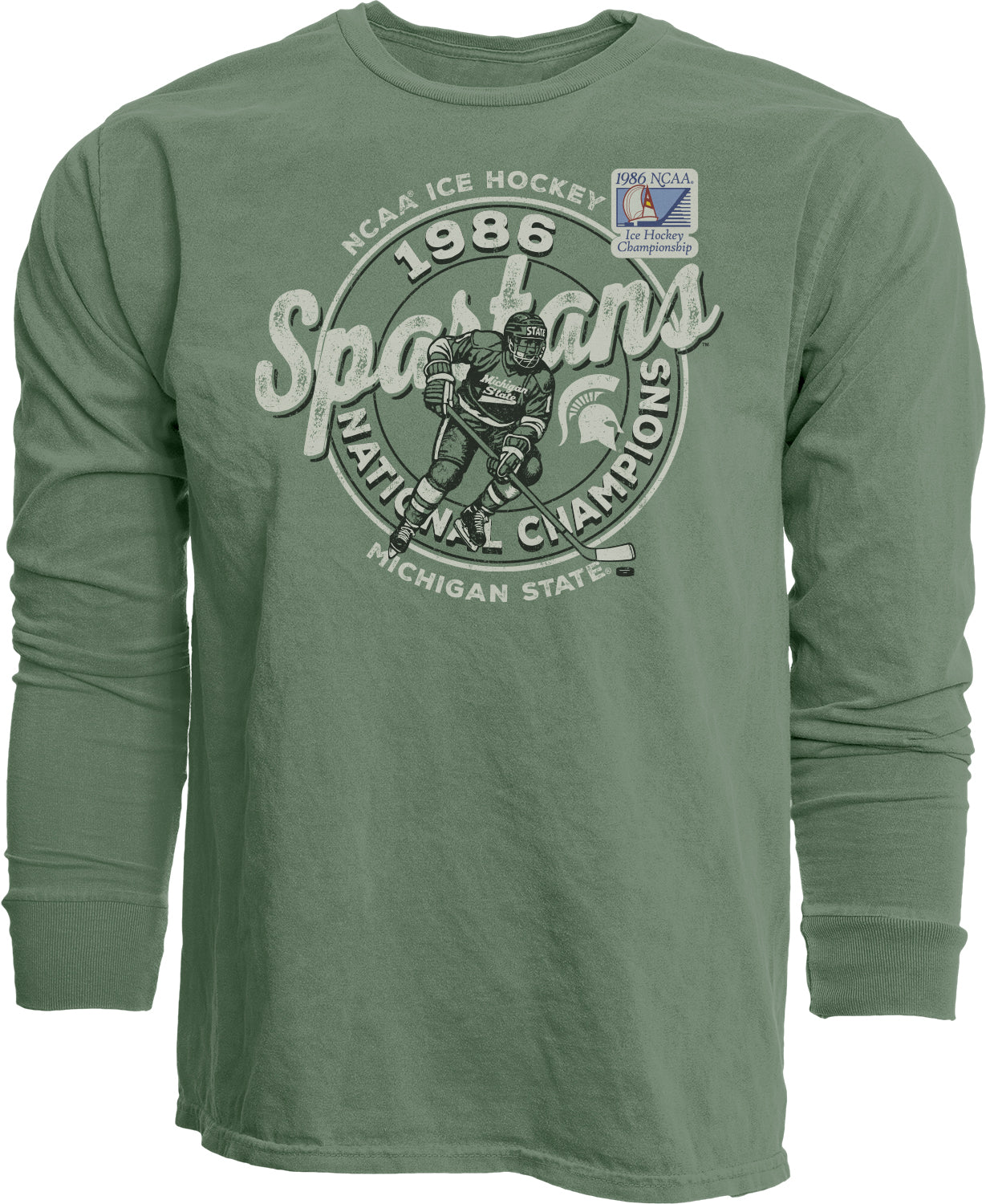 Green long-sleeve shirt with hockey themed graphics, "Champions 1986 Michigan State" text and the 1986 NCAA Ice Hockey Championship patch. Shown on a white background.