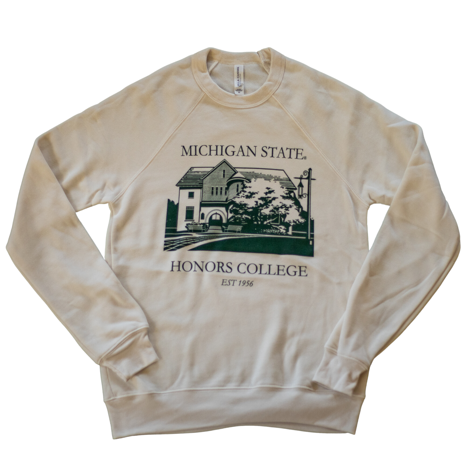 A natural/tan colored crewneck sweatshirt. On the torso of the sweatshirt in green is an image of the first MSU Honors College building. Around the image is the text "Michigan State Honors College est. 1956."