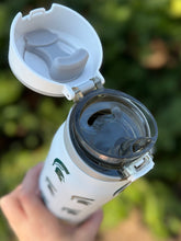 Opening to water showing venting hole and mouth piece. showing inside of lid with silicone pieces to create secure closure of bottle.