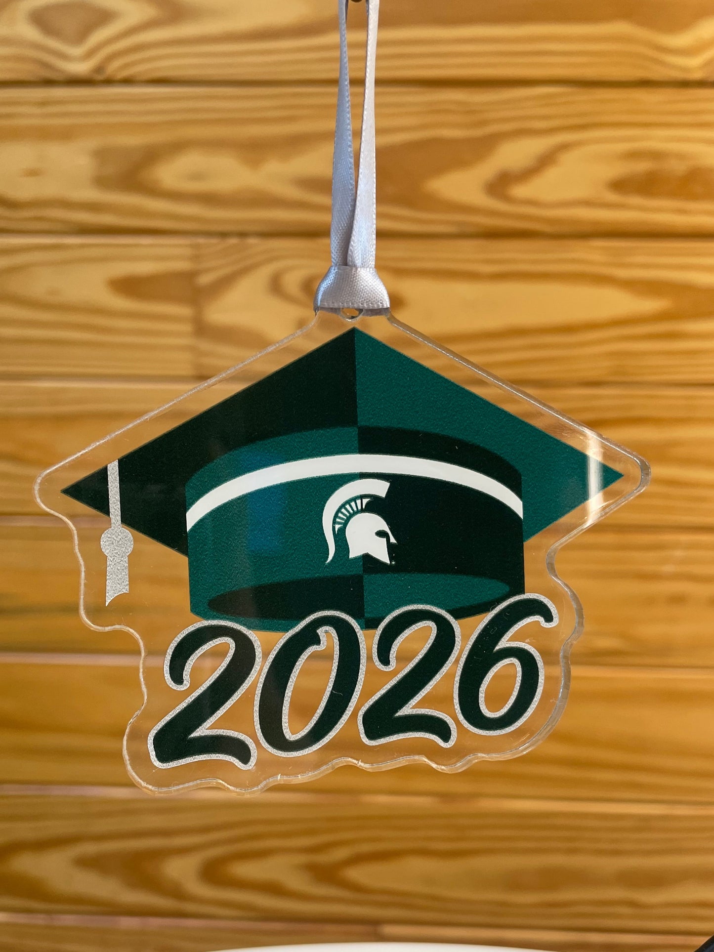 Acrylic cutout of a green graduation cap with white Spartan Helmet logo and "2026" below.