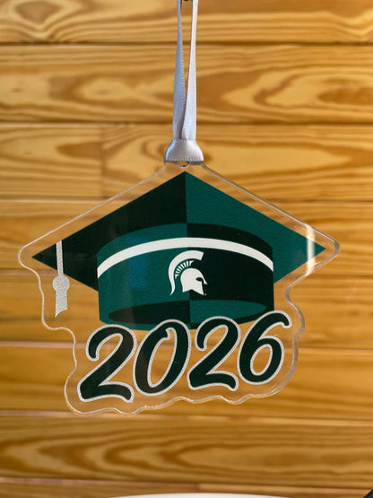 Acrylic cutout of a green graduation cap with white Spartan Helmet logo and "2026" below.