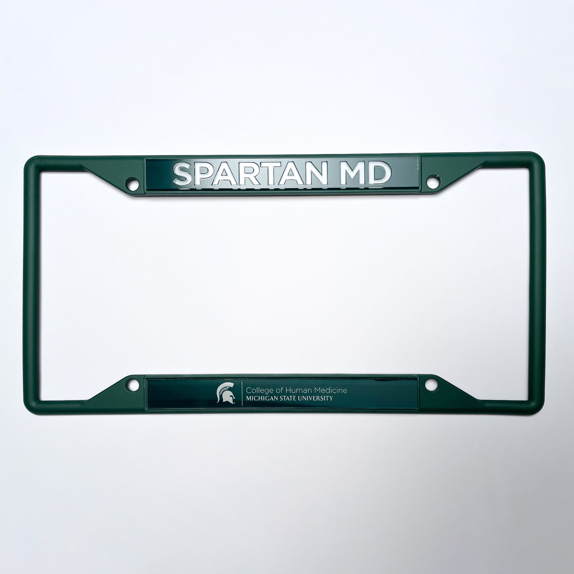 Green license plate frame with "Spartan MD" text at the top and the Michigan State University logo at the bottom, accompanied by the text "College of Human Medicine Michigan State University" in white.
