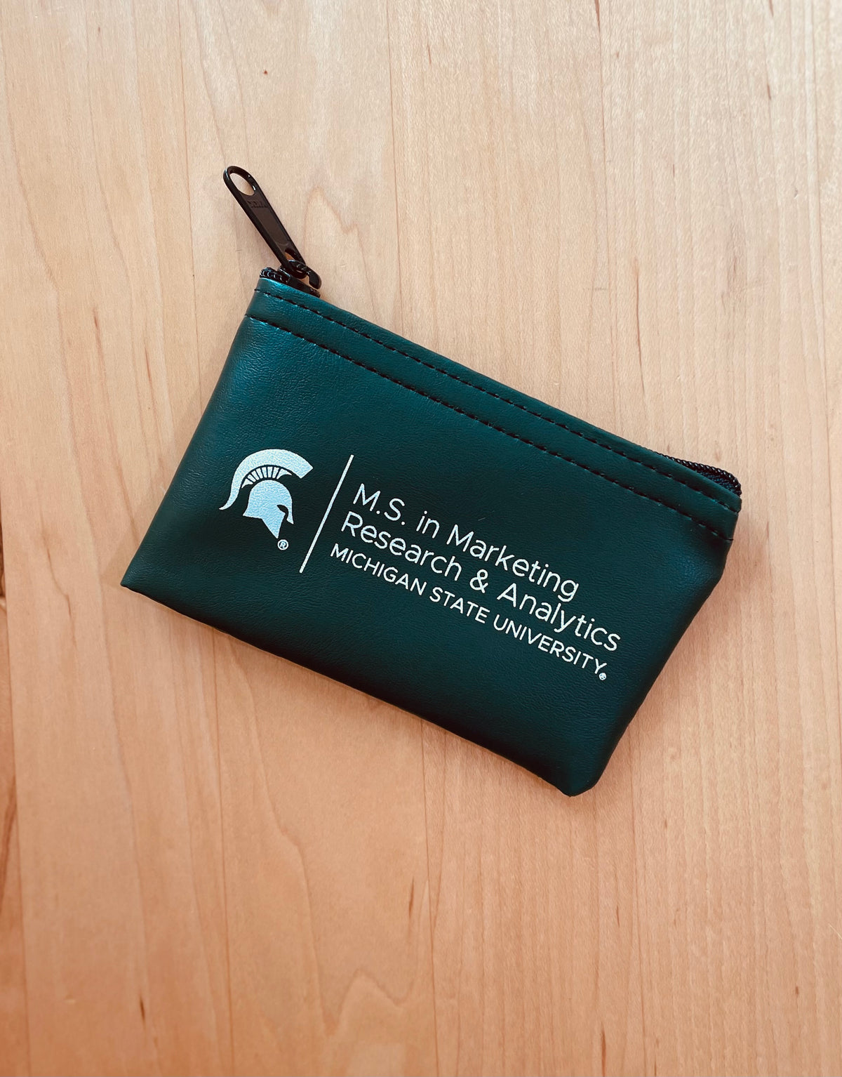 Green zipper pouch with the M.S. in Marketing Research & Analytics Michigan State University logo printed in white. 