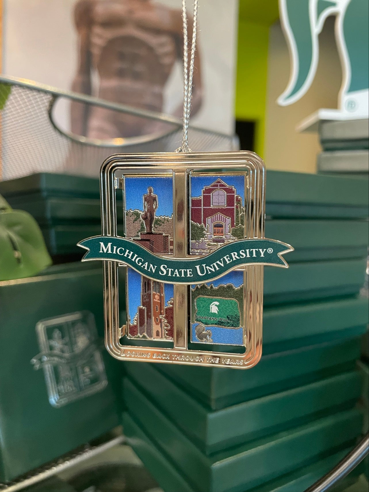 Collectible ornament in the shape of a window frame with 4 images from across the Michigan State campus; Spartan statue, Union, Beamont Tower, and the Rock.