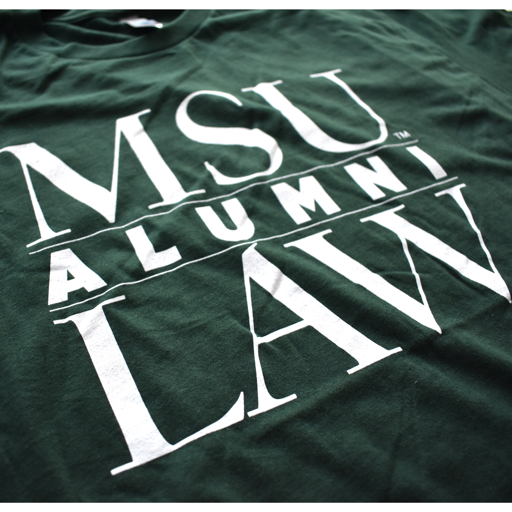 Close-up of graphic text covering three lines that read MSU Law Alumni in all caps, with alumni being in the center separated by two thin white lines.