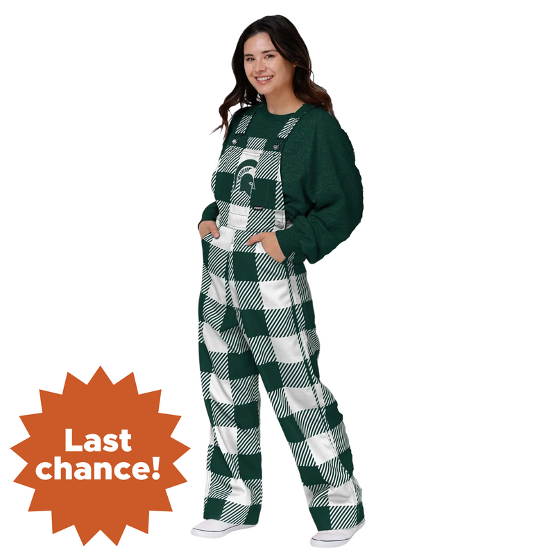 A woman wearing plaid Michigan State overalls. The colors alternate between green and white. In the center torso is a green MSU helmet logo. In the lower left corner is an orange sunburst with the words "Last chance!"