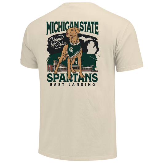 Back of a cream T-shirt with Zeke the dog on it and text that reads "Home of Zeke" next to it. Behind the dog graphic is a MSU themed design with stacked text below that reads "Spartans East Lansing."