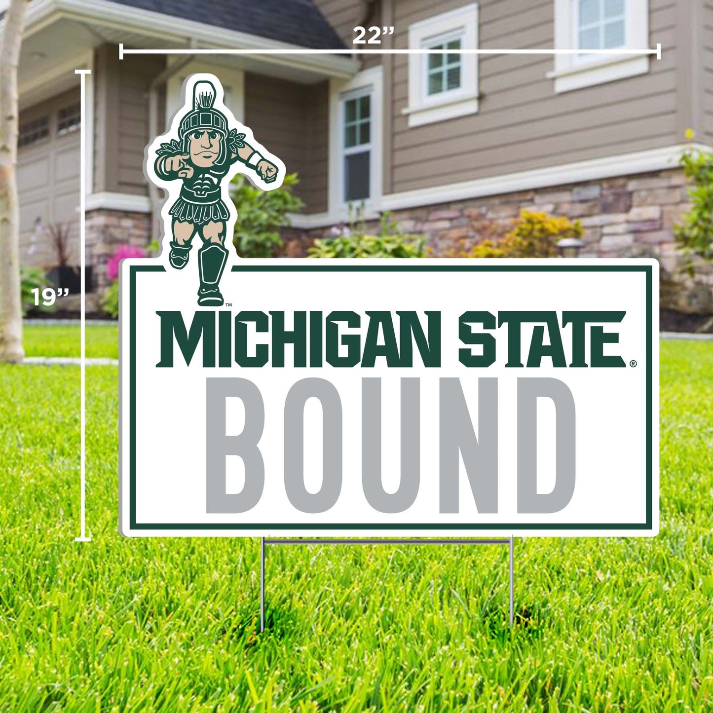 A white rectangular lawn sign with 'MICHIGAN STATE BOUND' text in green and gray, and a running Sparty logo at the top. 