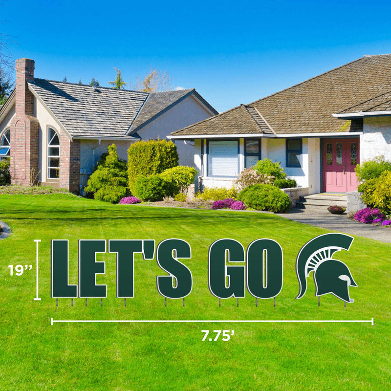 A lawn display that says 'LET'S GO' with the partan helmet at the end in green outlined in white, set against a residential background.