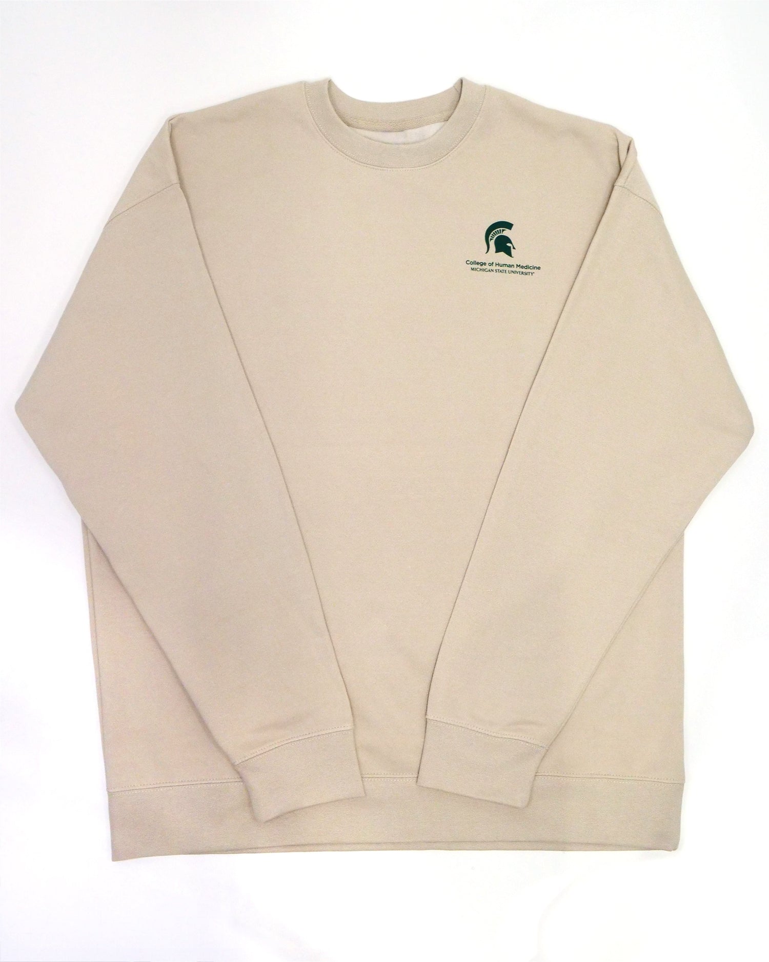 The front of a cream crewneck sweatshirt. In the top left corner is a green Spartan Helmet logo with the words "College of Human Medicine, Michigan State University" written in green underneath. 