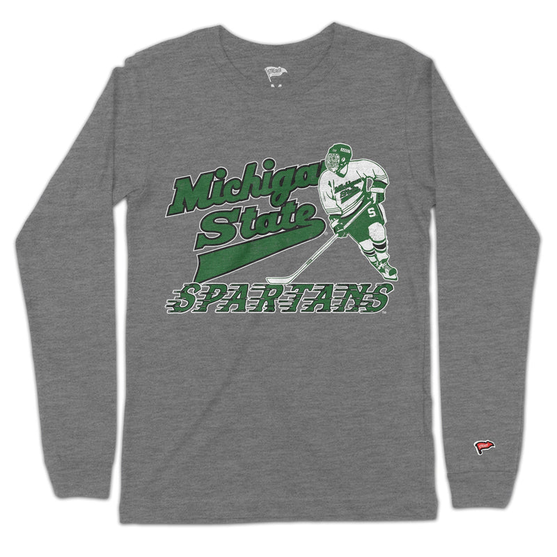 A gray long sleeve t-shirt with a green "Michigan State Spartans" design in a hockey font beside a hockey player.