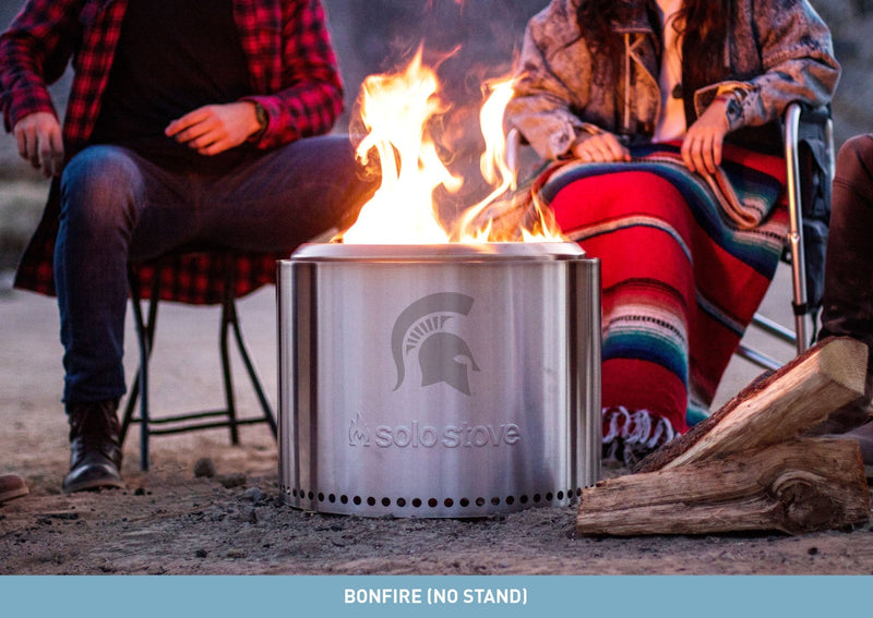 A stainless steel bonfire pit with a laser-etched Spartan helmet on the side.