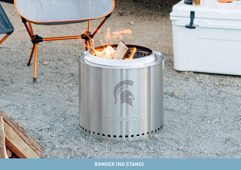 A stainless steel bonfire pit with a laser-etched Spartan helmet on the side.