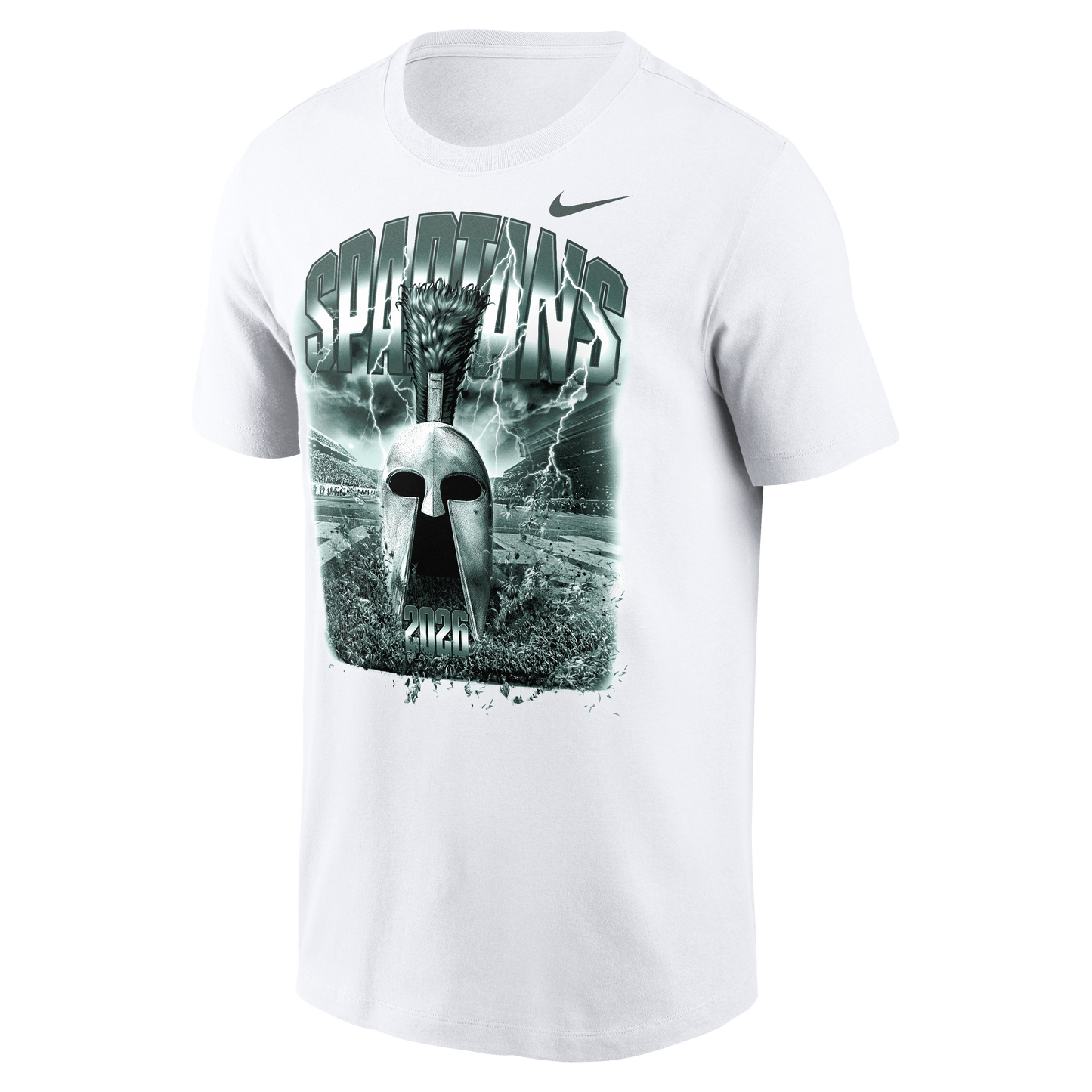 White Nike Michigan State Spartans T-shirt featuring a large green-toned graphic of a Spartan helmet centered on the chest. The design includes bold “SPARTANS” lettering, lightning effects, a stadium backdrop, and “2026” at the bottom of the artwork. A Nike Swoosh logo appears above the graphic on the upper right chest. Product shown on a light gray background.