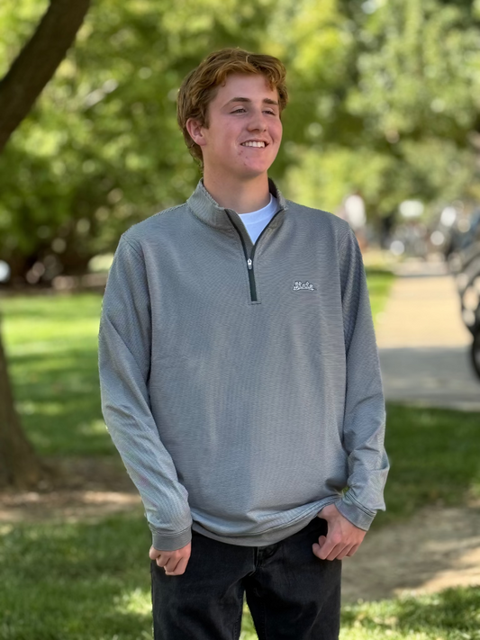 Person standing outdoors, wearing a green and white striped quarter-zip pullover with a "State" wordmark logo on the left upper chest. 