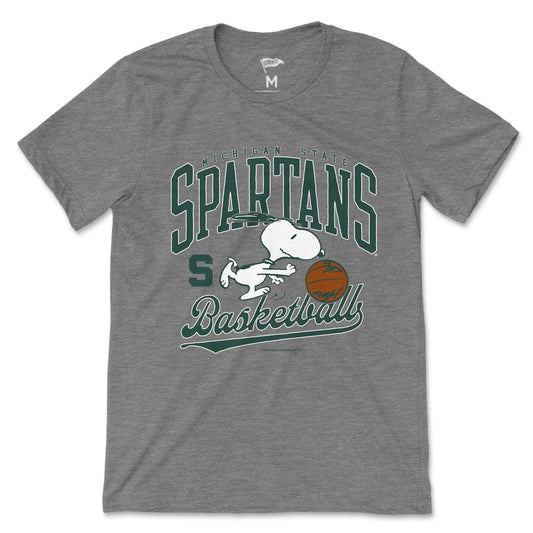Gray Michigan State Spartans T-shirt featuring Snoopy playing basketball with a green and white “SPARTANS” graphic and “Basketball” script lettering.