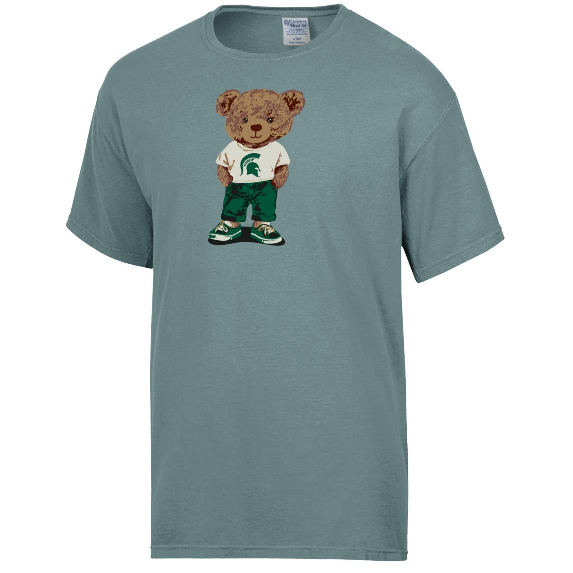 Blue green T-shirt with a brown teddy bear graphic, wearing a white T-shirt with a green Spartan Helmet logo on it, green pants, and green and white shoes. 