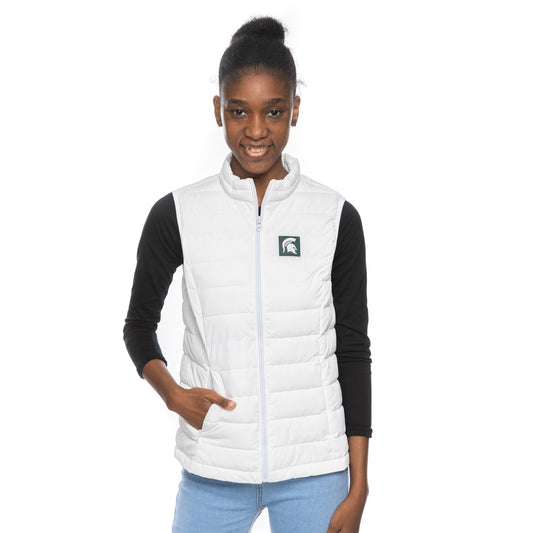 Woman facing forward with hand in pocket, wearing a white puffer vest that has a small green box with a white Spartan Helmet logo in it at left chest. Underneath the puffer, she has on a long-sleeve black T-shirt and jeans.