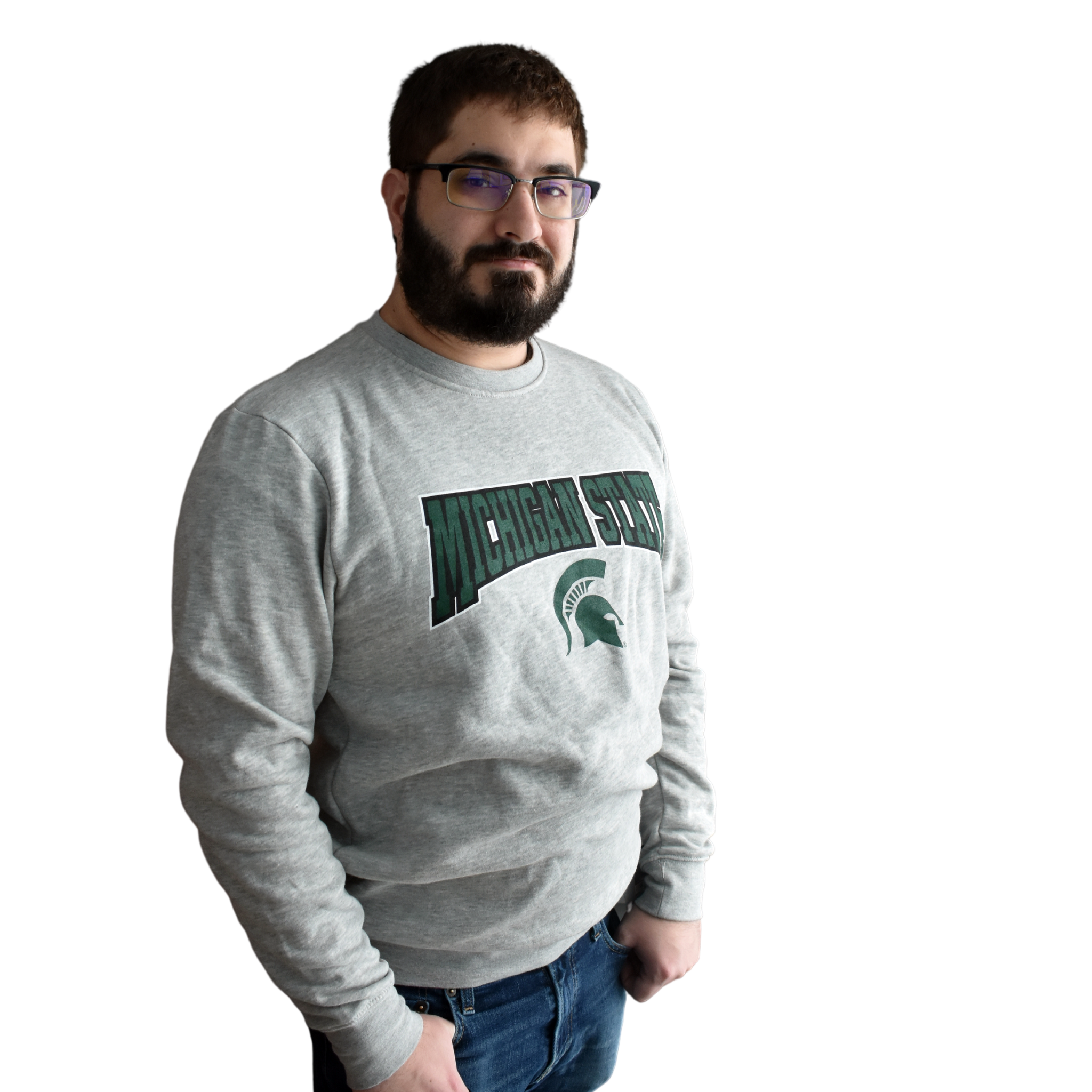 Man wearing a light heather gray crewneck sweatshirt, with Michigan State printed in a graphic arch over a Spartan helmet on the center chest.
