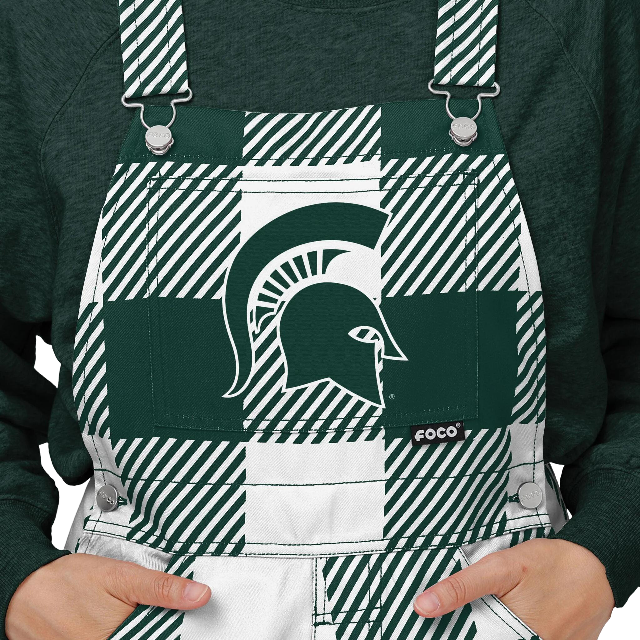 Close up of plaid Michigan State overalls. The colors alternate between green and white. In the center torso is a green MSU helmet logo.