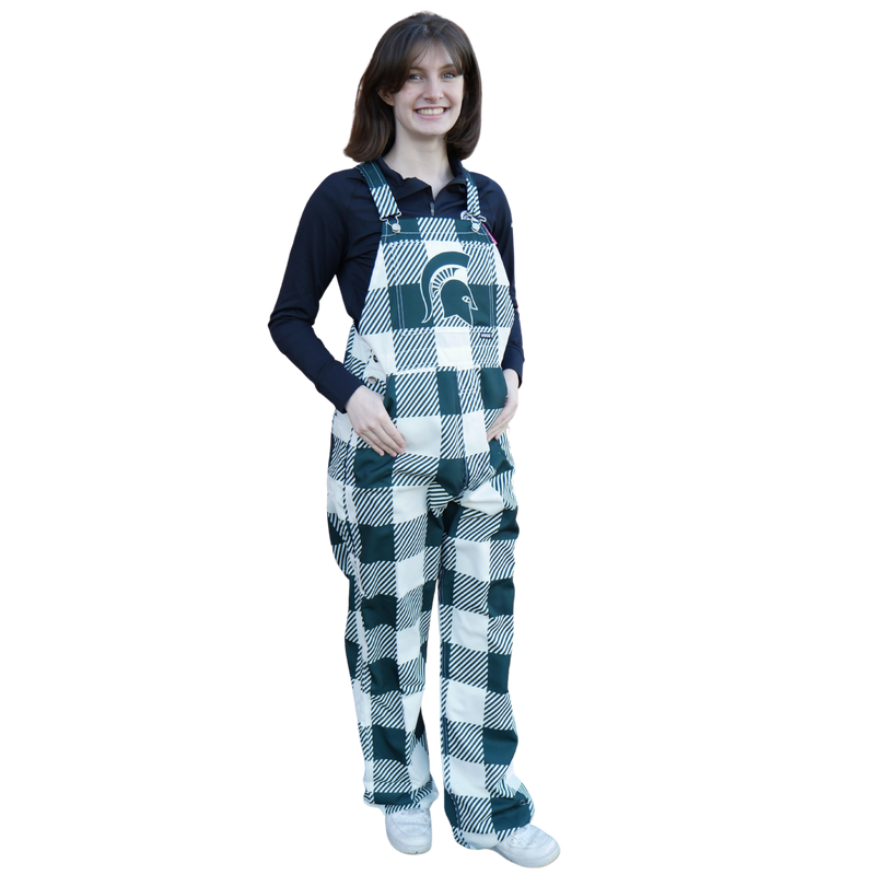A woman wearing plaid Michigan State overalls. The colors alternate between green and white. In the center torso is a green MSU helmet logo.