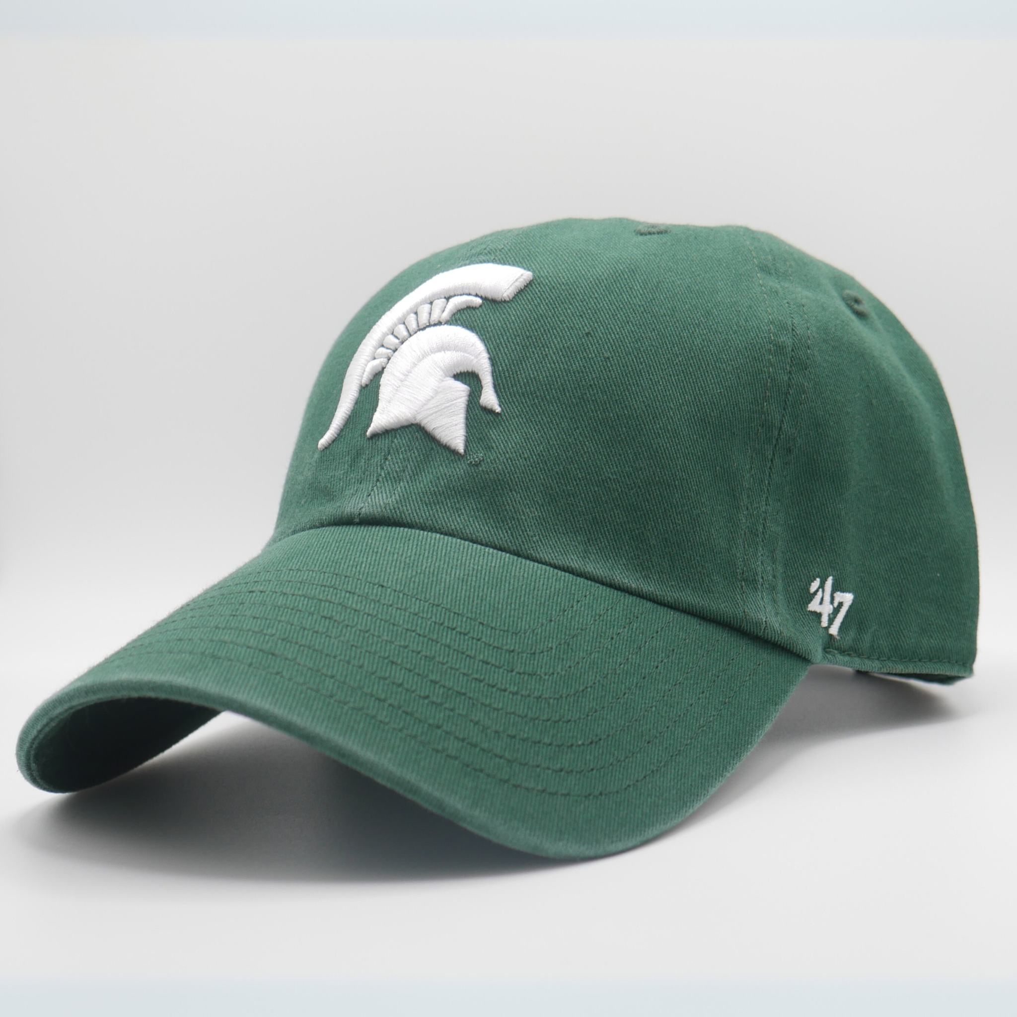 A green baseball cap with a white Michigan State Spartan helmet logo on the front center of the hat. 
