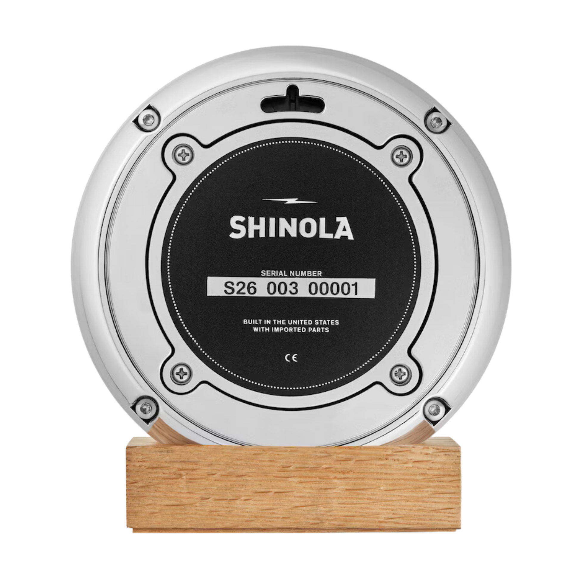 Shinola desk clock case back on a wooden stand.