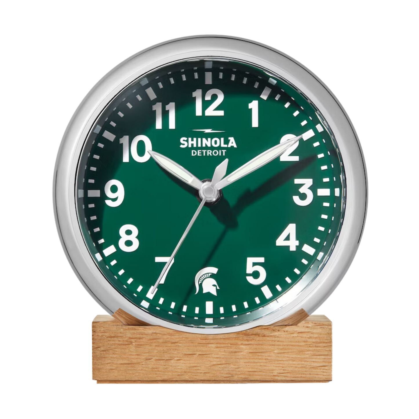 Front of the Shinola desk clock with a green face, wooden base, and silver rim. The numbers are white and there is a white Spartan Helmet logo in place of the number 6.