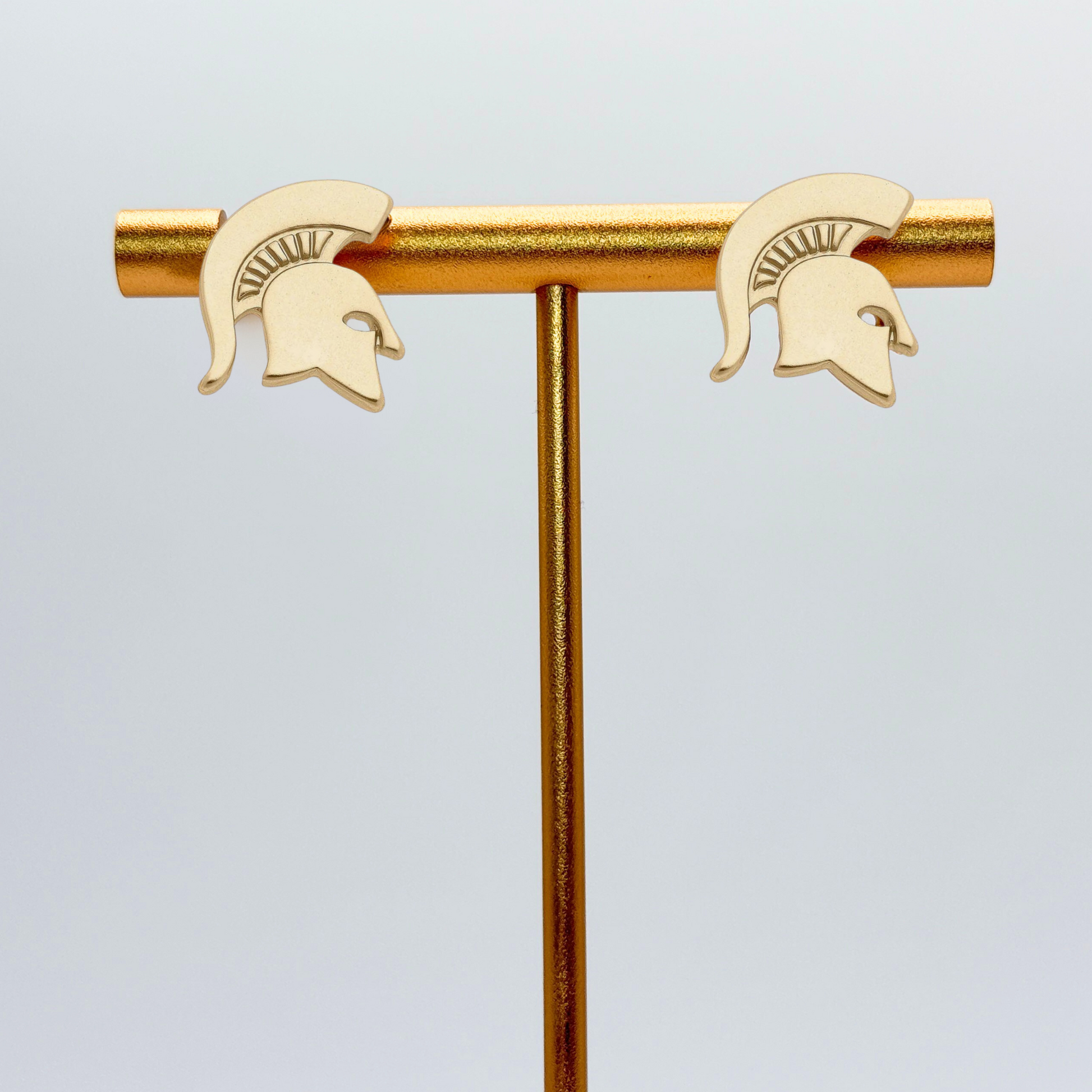 A pair of gold plated stud earrings shaped as a Spartan Helmet logo. 