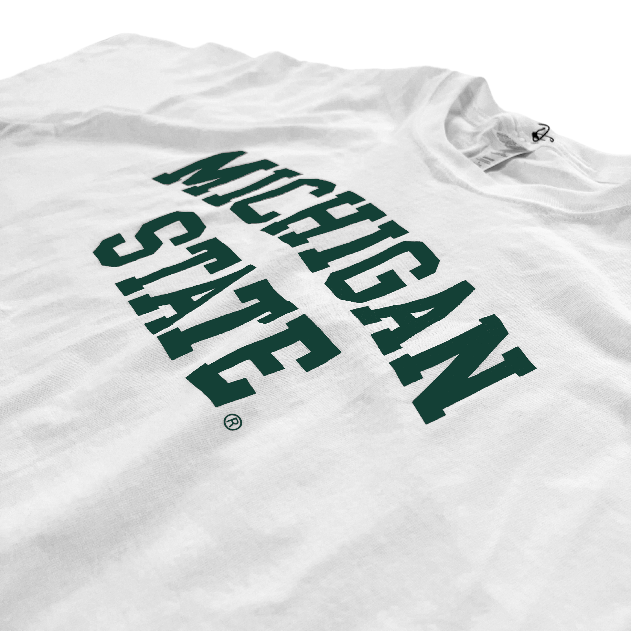 Close up of the chest area of a white t-shirt. Forest green block letters read "Michigan State" across two lines, with "Michigan" slightly arched.