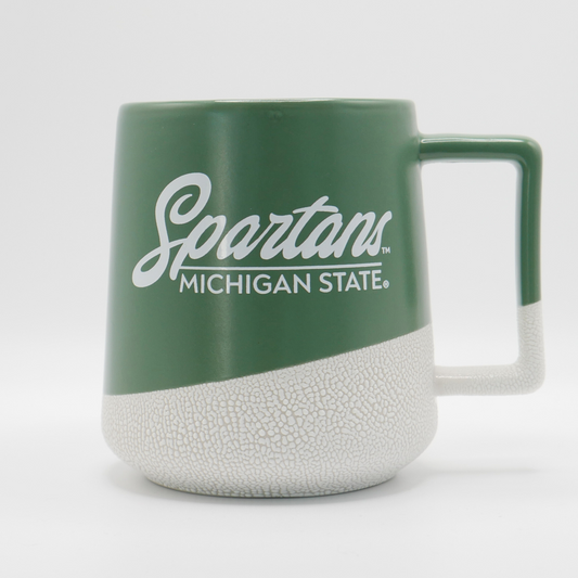 A green and ceramic printed coffee mug with "Spartans: Michigan State" written in white on the front in cursive and all caps print. 