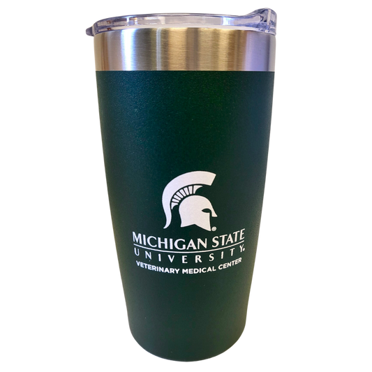A curved stainless steel drink tumbler with a forest green powder coating and a silver rim at the top. Printed in white on one side is a large Spartan helmet logo centered over the Michigan State University wordmark logo and bold block letters reading “Veterinary Medical Center.”
