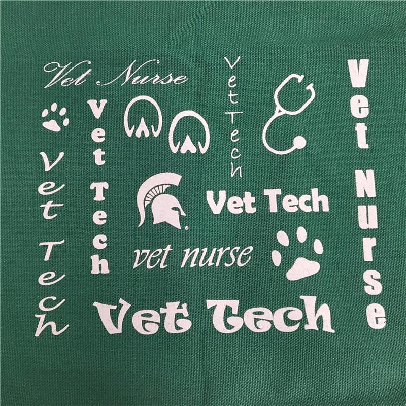 Close of the green canvas tote bag, showing the white text and symbols related to veterinary technology and veterinary nursing. 