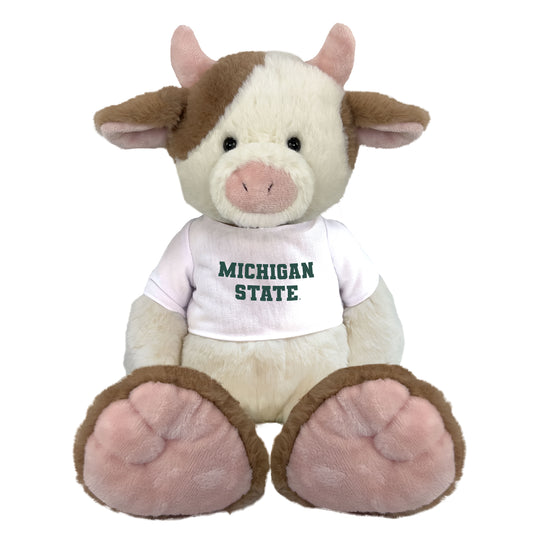 Light brown and white plush cow wearing a white 
'Michigan State' shirt. 