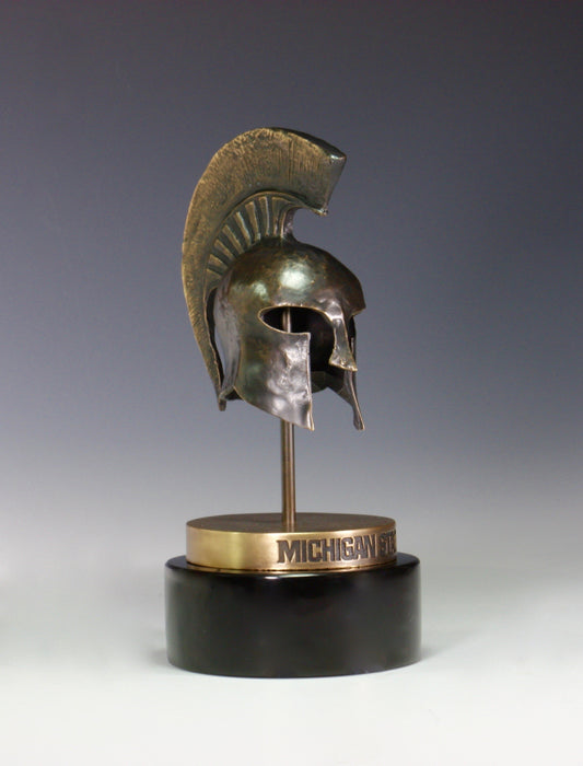 A bronze Spartan Helmet statue on a black base.
