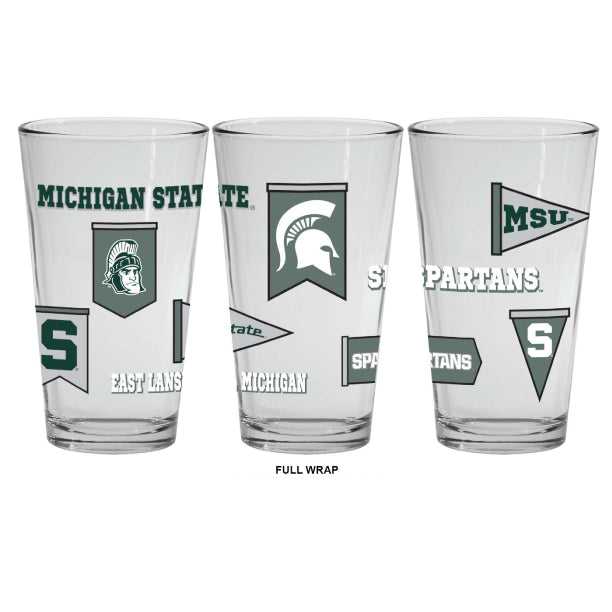 Clear glass Michigan State Spartans pint glass featuring a full-wrap design with multiple team graphics, including the Spartan helmet logo, block "S," Michigan State wordmark, pennant-style banners, "Spartans" text, "MSU," "State," and "East Lansing, MI." Product is shown from three angles to display the complete wraparound design on a light gray background.