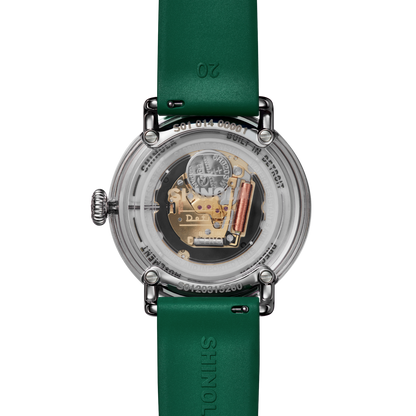 Back view of green Shinola watch with green face and strap featuring white numbers and a white Spartan Helmet logo. Stainless-steel watch casing. 