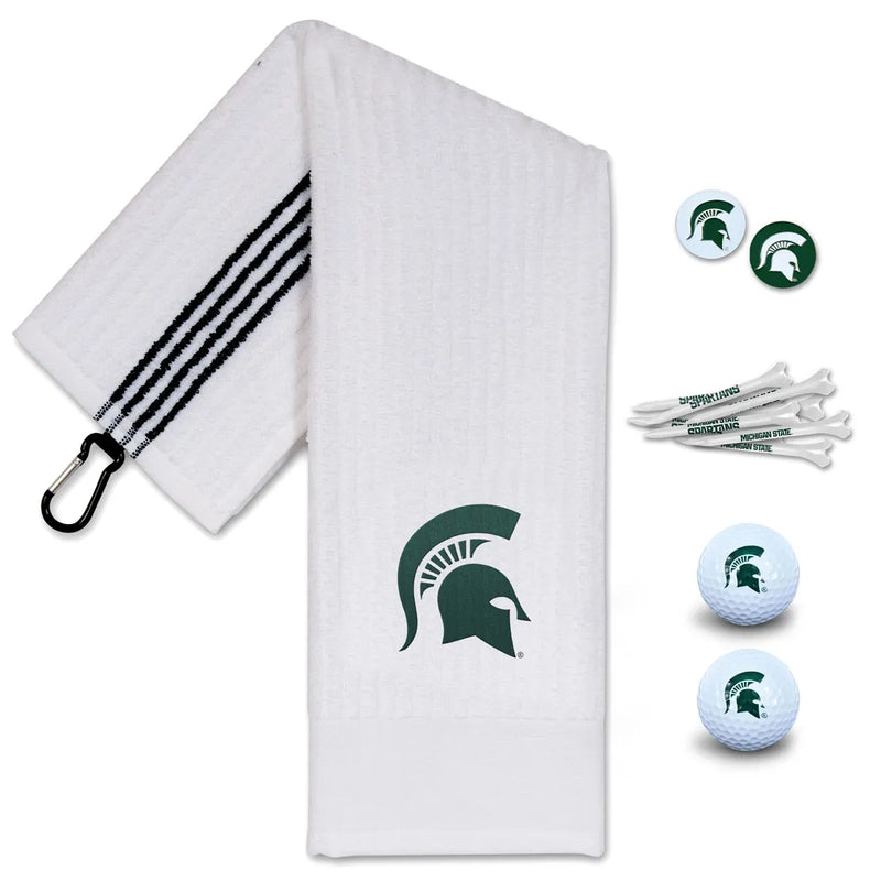 A white Michigan State golf towel with a green Spartan helmet logo beside Spartan helmet ball markers, Michigan State tees, and Michigan State golf balls.