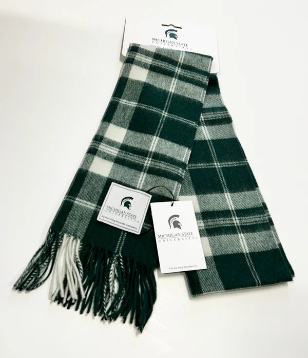 Green and white plaid scarf with fringe on the ends, featuring Michigan State University branding on tags and packaging.
