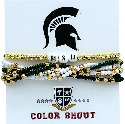 Gold, green, and white stack of beaded bracelets. The top bracelet is gold with white beads that have the letters M, S, and U written on them. The bracelets underneath are white and green with gold enamel and they are intertwined together.